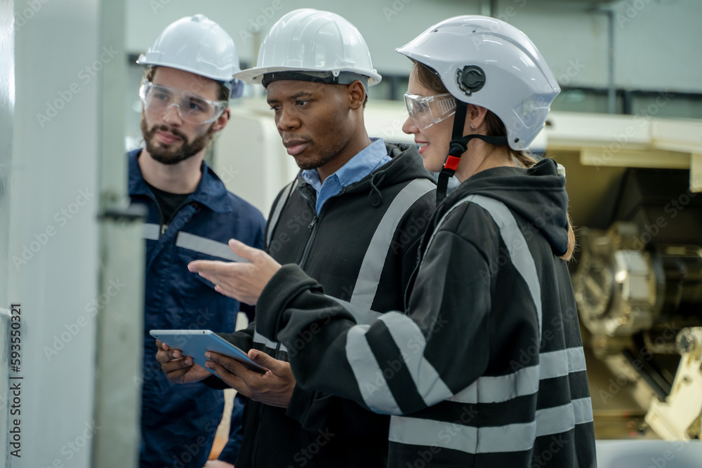 Poster Engineer using laptop for programming modern robot arm in automated manufacturing industry,Factory worker with responsibility for programming industrial machine to control the process of production.