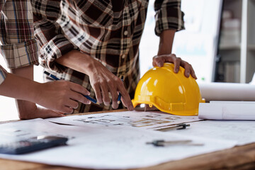Architect and Engineer working with blueprints for architectural plan, engineer sketching a construction project, green energy concept