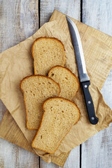 Bread on wooden board. Homebaked bread. Natural food. Slices of bread and a knife on a wooden table.