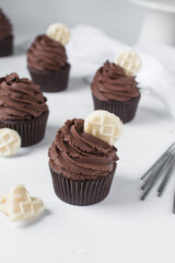 Chocolate cupcake with dark chocolate buttercream, double chocolate cupcakes with american buttercream, tall swirl frosting on a cupcake with a wafer