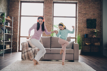 Photo of sweet cheerful mother daughter wear casual outfits listening songs having fun together indoors house room