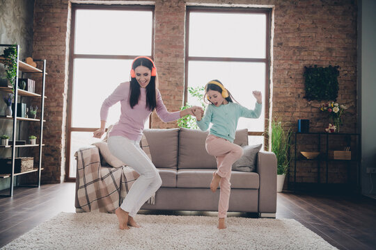 Photo of sweet cheerful mother daughter wear casual outfits listening songs having fun together indoors house room