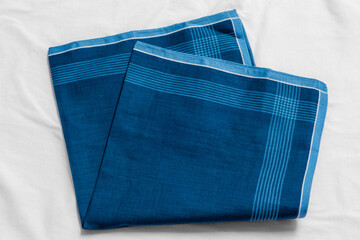 Vintage men's blue striped handkerchief on white fabric.