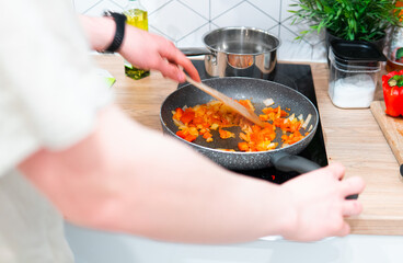 close-up of a man cooking dinner in a frying pan.