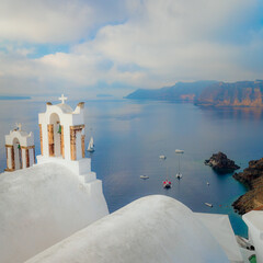 Santorini, Greece. Conceptual composition of the famous architecture of Santorini island. White bell arch and blue sea view with boats. Santorini island, Greece, Europe.