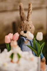 Vertical shot of the bunny and cake with flowers for Easter decoration