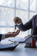 real estate agent insurance sales representative And a young Asian businessman handing over the...