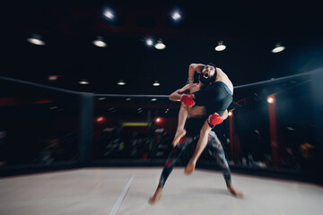 Boxers Aggressive fighter in MMA tournament in ring cargo octagon, dark background spot light