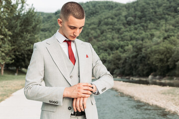 Young teenage boy looking at his watch. Ready for a prom night. © stivog