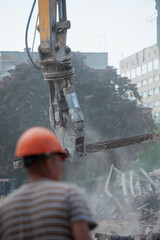 Demolition of building. Excavator breaks old house. Freeing up space for construction of new building