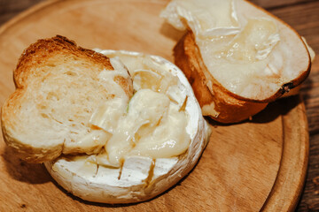 White baguette with olive oil and baked Camembert cheese on the table.