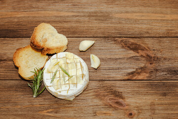 White baguette cut into pieces with olive oil and Camembert cheese on the table.