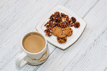Healthy breakfast oat round granola with nuts on a plate and coffee, seed cookies.