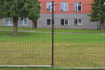 New metal lattice fence on the background of the building.