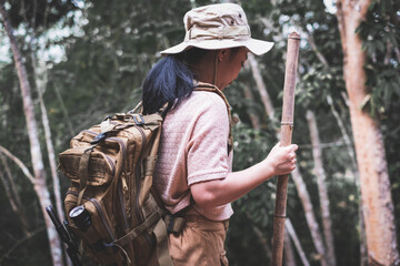 Young woman with backpack hiking in the deep jungle