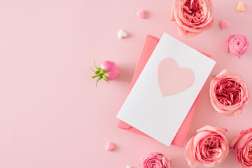 Top view photo of postcard with heart natural flowers pink rose buds and small hearts on isolated pastel pink background with empty space. Mother's Day love concept