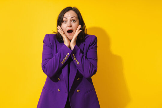 Suprised Middle Aged Woman Wearing Purple Blazer Against  Yellow Background