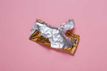 Empty chocolate packaging, crumpled aluminum foil candy bar
