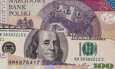 100 dollar banknote through torn 20 Polish zloty banknote