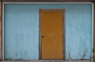 古い青い壁とオレンジ色の扉