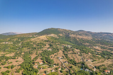 Fototapeta na wymiar Aerial view of traditional village with rural houses, buildings, highway bridge, countryside roads in Greece. Drone, copter view