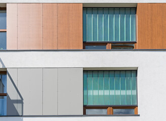 Detal na nowoczesny budynek wielorodzinny w europejskim mieście. Ciekawy układ okien i materiału - obrazy, fototapety, plakaty