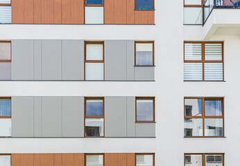 Detal na nowoczesny budynek wielorodzinny w europejskim mieście. Ciekawy układ okien i materiału