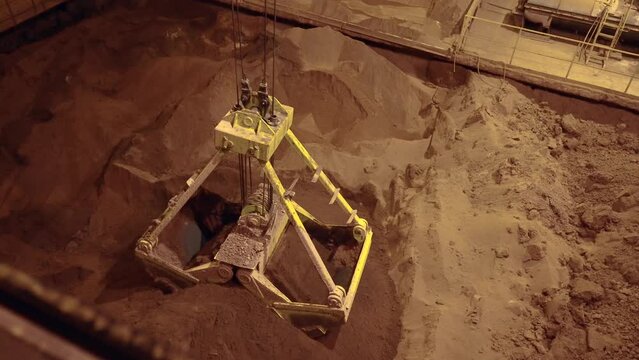 Follow shot of clamshell bucket getting clay. 4k.