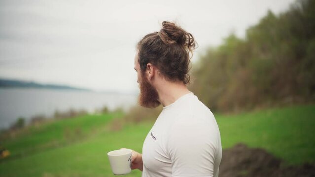 A Bearded Man Drinking Coffee Outside With Nature Background. Selective Focus Shot
