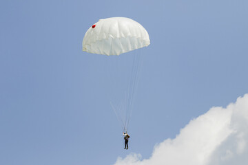skydiver in the sky with a round landing parachute