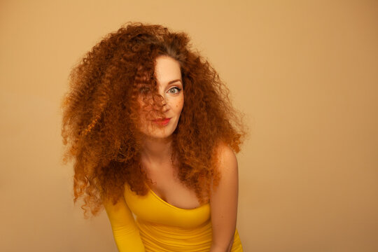 beautiful red haired curly girl in a yellow dress