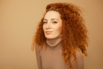 beautiful red-haired curly girl in a lilac turtleneck