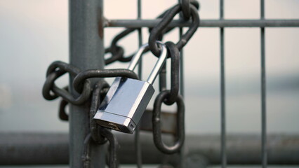 Naklejka premium Closeup of lock at iron metal gate