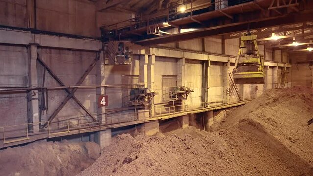 Mechanical crane grab bucket moving opening and dropping the load of clay. 4k.