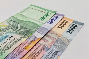 Close up of stacked Indonesian banknotes with isolated background.