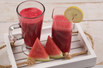 watermelon and lemon juice. Watermelon is a tropical fruit with red flesh. source of vitamins A and C, contain lots of water and fiber. suitable for diet. served in a clear glass. Citrullus lanatus.