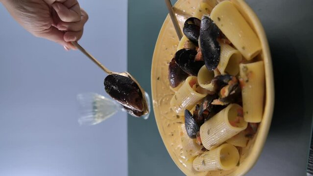 Italian pasta paccheri allo scoglio with mussels. Large Italian pasta with mussels and shrimps in sauce. From the South of Italy, typical Neapolitan pasta with seafood. High quality 4k footage