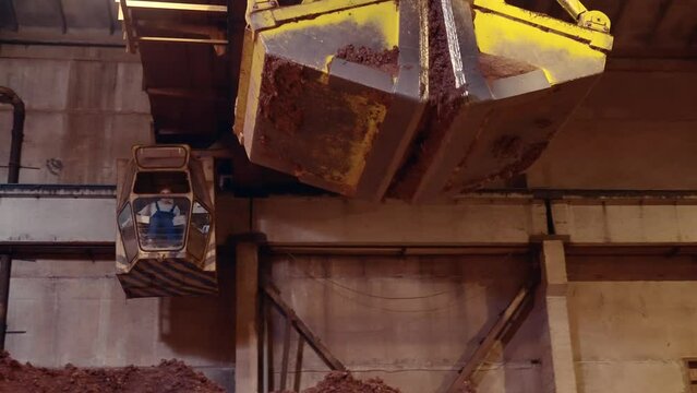 Follow shot of clamshell opening and dropping the load of clay. Slow motion 50perc. 4k.