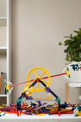Children's constructor of gears cogwheel and sticks in the children's room. Toys for the development of logic and thinking
