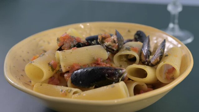 Italian pasta paccheri allo scoglio with mussels. Large Italian pasta with mussels and shrimps in sauce. From the South of Italy, typical Neapolitan pasta with seafood. High quality 4k footage