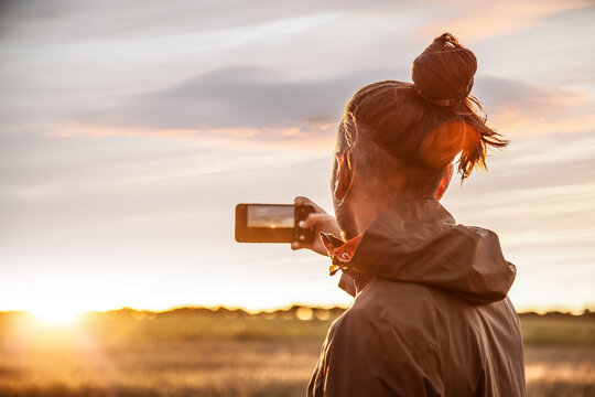 boy taking photos at sunset in nature