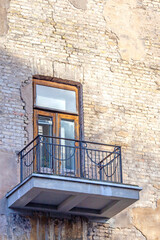 Fototapeta na wymiar Balcony of an old brick house, vertical photo