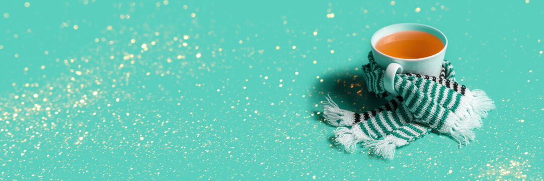 Mug of tea with warm scarves. Spring bad weather. Tea drinking on cold days.