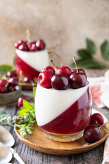 Panna cotta with sweet cherry jelly on a rustic table. Italian dessert, homemade cuisine. Copy space.
