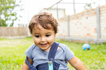 Baby playing at home curious with expression of contented surprise in her amusement. Mention children's play and motor and brain development and the importance of this phase.