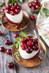 Panna cotta with sweet cherry jelly on a rustic table. Italian dessert, homemade cuisine.
