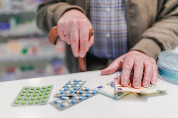 Close up of senior holding pills in a pharmacy.