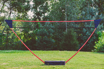 Portable badminton net and playing set at backyard lawn on summer day