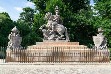 Monument to Jan III Sobieski with green trees on a sunny day at Lazienki Park in Warsaw, Poland