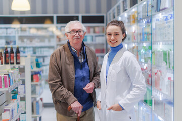 Obraz premium Portrait of young pharmacist and senior man in a pharmacy.
